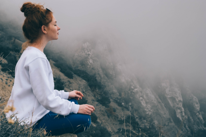 Women meditating on mountain side